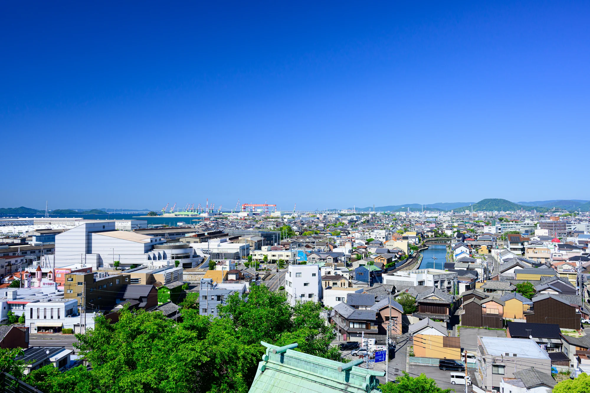 高台から見た多度津の町なみと、その先の港・造船所