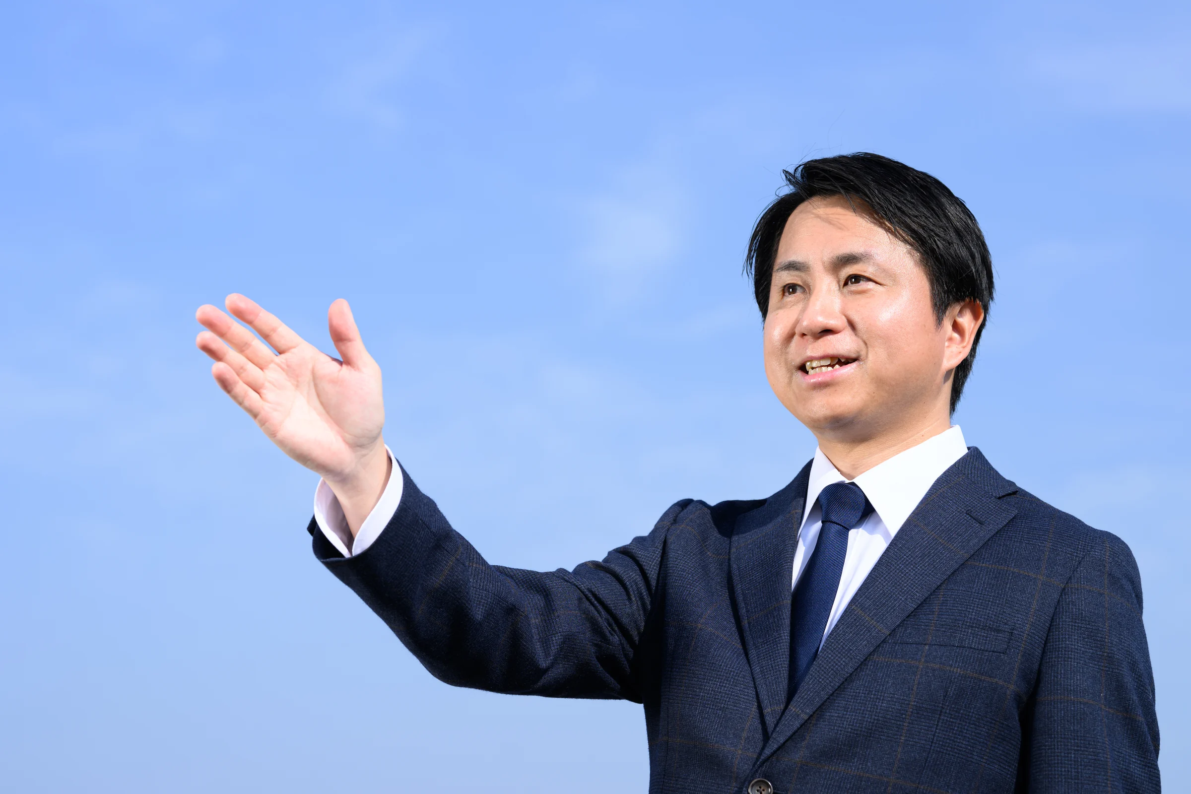 多度津の空を背景に語りかける新田やす道